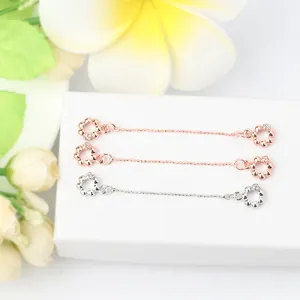 Makroaufnahme blumenförmiger Schmuckverschlüsse in Roségold und Silber mit feinen Kristallen