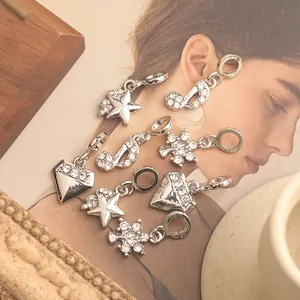 Macro detail of silver alloy lightning and star pendants with inlaid rhinestones for DIY