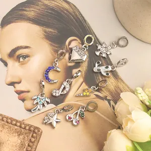Detailed macro of colorful rhinestone charms featuring celestial and botanical metal motifs