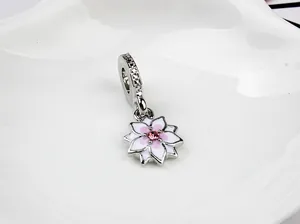 Detalle del colgante de magnolia de plata con esmalte rosa y centro de circón brillante