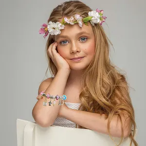 Gros plan d'une jeune fille portant un bracelet à breloques DIY avec pendentifs