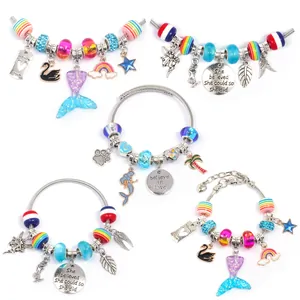 Macro shot of colorful glass beads, mermaid tail charms and engraved DIY bracelets