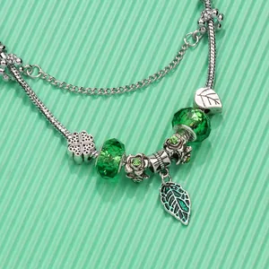 Garden-style leaf charm bracelet with green crystal beads and clover pendant on silver chain