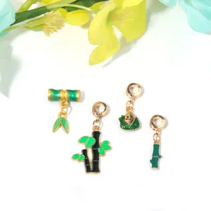 Détail des breloques en bambou plaqué or avec émail vert pour bijoux faits main