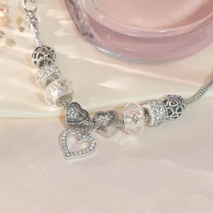 Macro view of crystal beaded bracelet with heart charm and lobster clasp detail