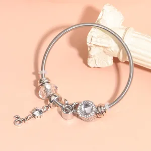 Detailed macro view of silver snake chain bracelet with charms and sparkling beads