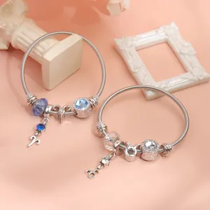 Detailed shot of silver zodiac charm bracelets with blue crystals on snake chains
