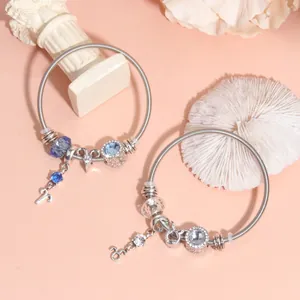 Detail of silver beaded bracelets with blue crystals and zodiac sign charms