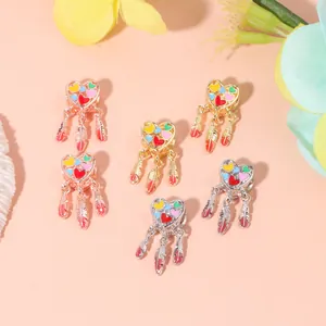 Macro detail of heart dreamcatcher charms with colorful enamel and feather dangles