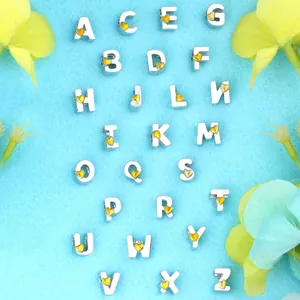 Detalle de 26 cuentas de alfabeto plateadas con corazón amarillo para joyería DIY