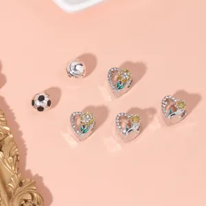 Detailed view of silver sunflower heart beads and sports charms with green enamel