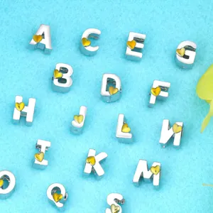 Detalle macro de cuentas de letras de aleación de plata con corazones dorados para bisutería