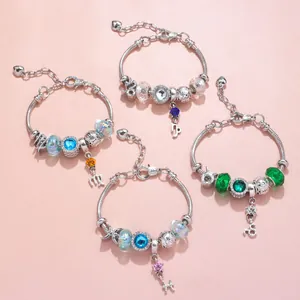 Detail of silver snake chain bracelets with colorful glass beads and zodiac charms