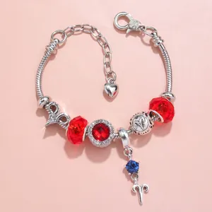 Detail of DIY Aries zodiac charm bracelet with red crystal beads and silver pendants