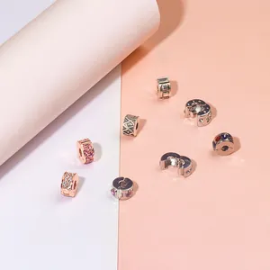 Silver and rose gold DIY charm beads with pave zircon and heart motifs on pink background