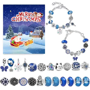 Detailweergave van DIY kerstarmbandset met blauwe sneeuwvlokken en kerstman-bedeltjes