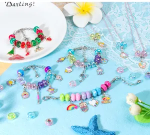 Macro-detail van DIY-bedelarmbandenset met regenboog-, eenhoorn- en Noel-hangers