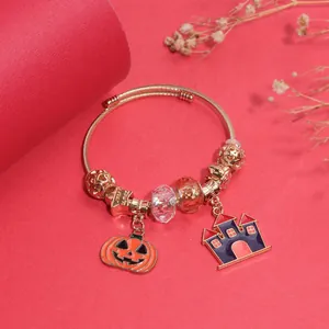 Λεπτομέρεια του βραχιολιού Halloween με χρυσή ταινία και γούρια κολοκύθας και κάστρου