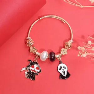 Λεπτομέρεια χρυσού βραχιολιού Halloween με μενταγιόν χάρου και μάσκας Scream