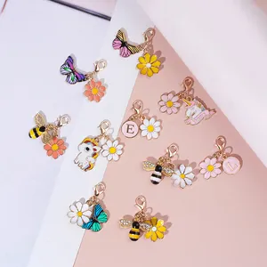 Detail van geëmailleerde vlinder en bij bedeltjes met gouden karabijnsluiting