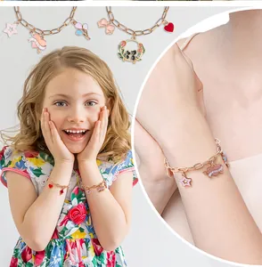 Girl wearing charm bracelet with gold chain and colorful enamel star and heart pendants