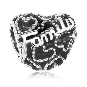 Macro shot of silver heart charm with Family engraving and black enamel bead detailing