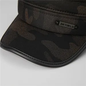 Detail of winter camouflage flat top hat featuring metal brand plaque and leather trim
