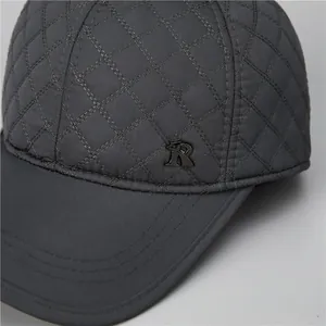 Detailansicht der dunkelgrauen gesteppten Baseballkappe mit Rautenmuster und Metall-R-Logo