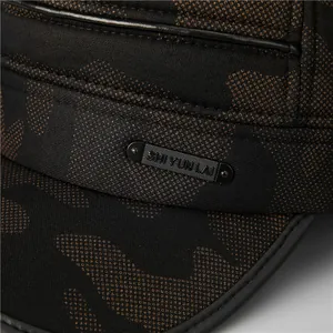 Detail of winter camo military cap showing textured fabric and matte metal logo plate