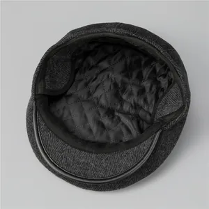 Detail of herringbone wool cap featuring quilted lining and premium leather piping edge