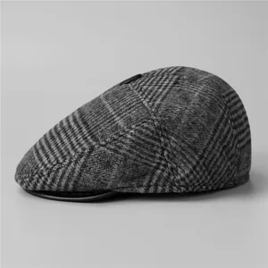 Close-up of gray plaid wool cap with black leather trim and premium textured finish