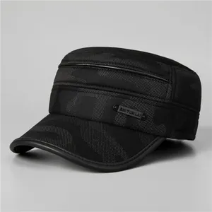 Detailed view of winter military cap with dark camo pattern and metal logo plaque