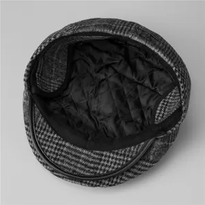 Detail of vintage grey plaid newsboy cap showing quilted lining and warm interior