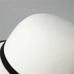 Elegant white wool felt cloche hat with black decorative band and vintage round top design