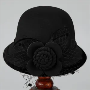 Detail of vintage wool cloche hat with black mesh veil and large flower decoration