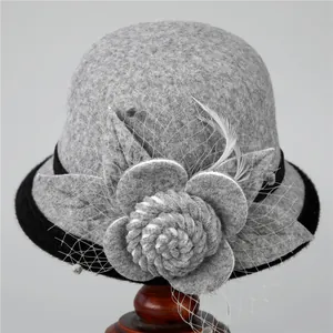 Detailed view of gray wool cloche hat featuring felt flower mesh veil and feather accents