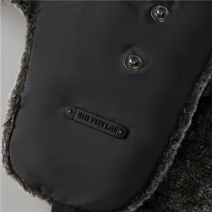Dettaglio del cappello invernale con fodera in ecopelliccia grigia e bottone a pressione