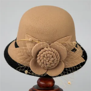 Close-up of elegant camel wool felt hat featuring mesh veil and handmade flower detail