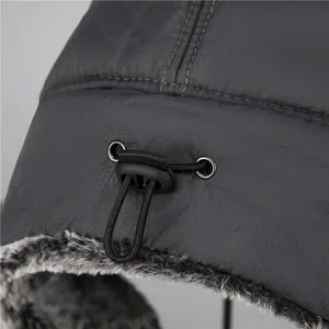 Detail of adjustable drawstring and waterproof textured fabric on men's winter trapper hat