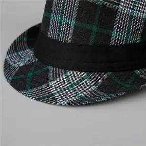 Dettaglio ravvicinato di cappello fedora scozzese verde e nero con nastro decorativo