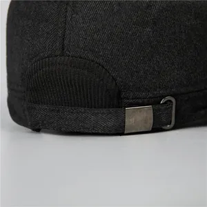 Detail of dark grey textured flat cap showing adjustable metal buckle and thick twill fabric