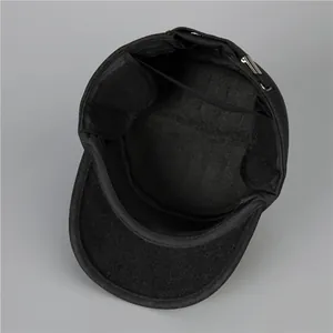 Close-up of winter flat top cap interior with fold-out ear flaps and metal buckle