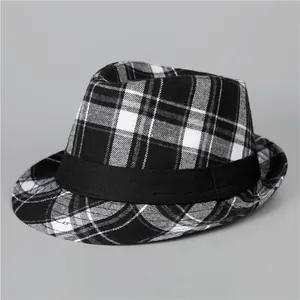 Dettaglio della trama del tessuto a quadri e del nastro nero sul cappello fedora