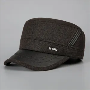 Detail of dark brown cadet cap with faux leather brim and metallic sport badge
