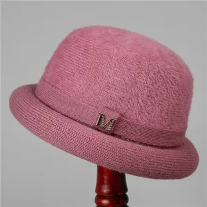 Detailed view of pink knitted wool hat featuring a plush texture and metallic M buckle