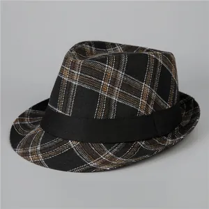 Dettaglio del cappello fedora classico a quadri con nastro nero e trama vintage scozzese