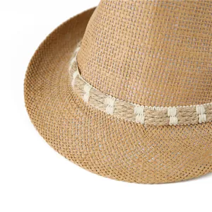 Macro detail of natural straw hat texture with decorative woven rope band on white background