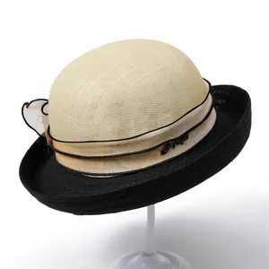 Detail of the elegant two-tone linen sun hat with ribbon and metal letter plaque