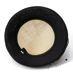 Detailed interior view of a black woven straw hat featuring elegant mesh trim and texture