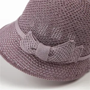 Détail du chapeau de soleil en tricot violet avec tissage ajouré et nœud décoratif latéral